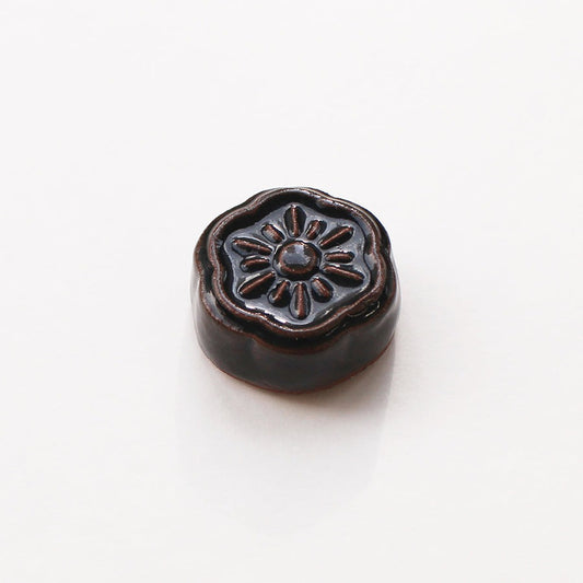 Small grey flower shaped ceramic magnetic needle rest by cohana on white background