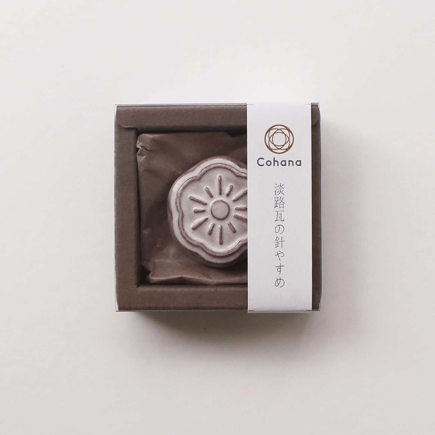Small white ceramic needle rest by cohana in box on white background