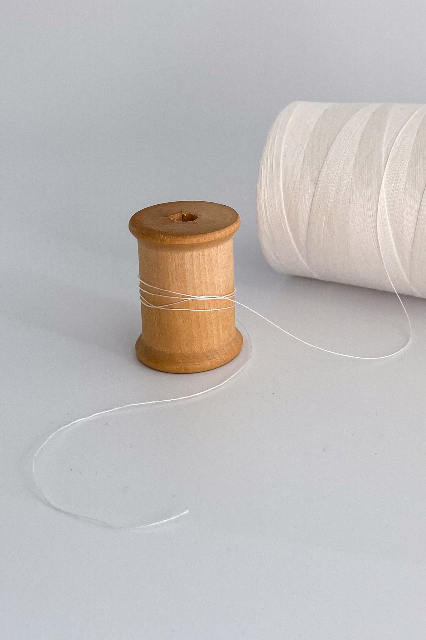 Close up of tencel sewing thread in natural wound around wooden cotton reel