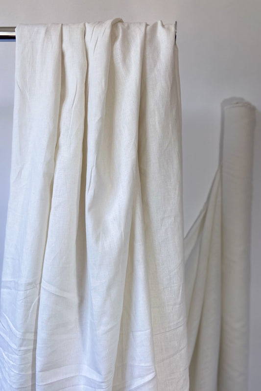 Natural white Organic cotton and hemp woven sewing fabric draped over clothes rail