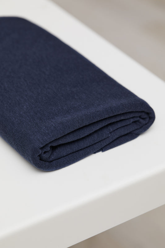 Navy organic cotton and tencel jersey sewing fabric folded on top of white table