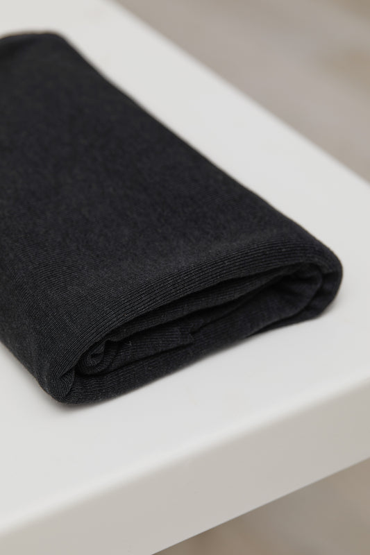 Black organic cotton and tencel knit sewing fabric folded on top of white table