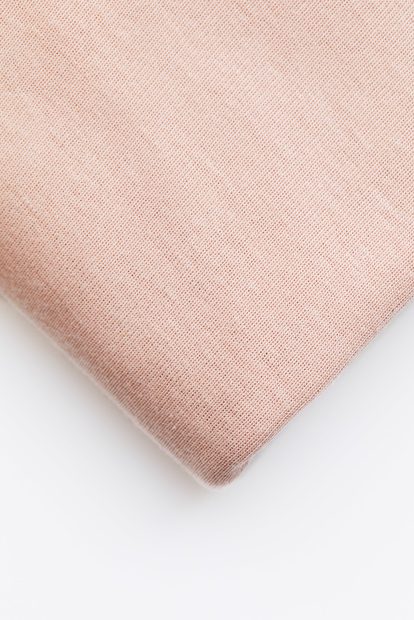 Close up of powder pink organic cotton and tencel knit jersey sewing fabric