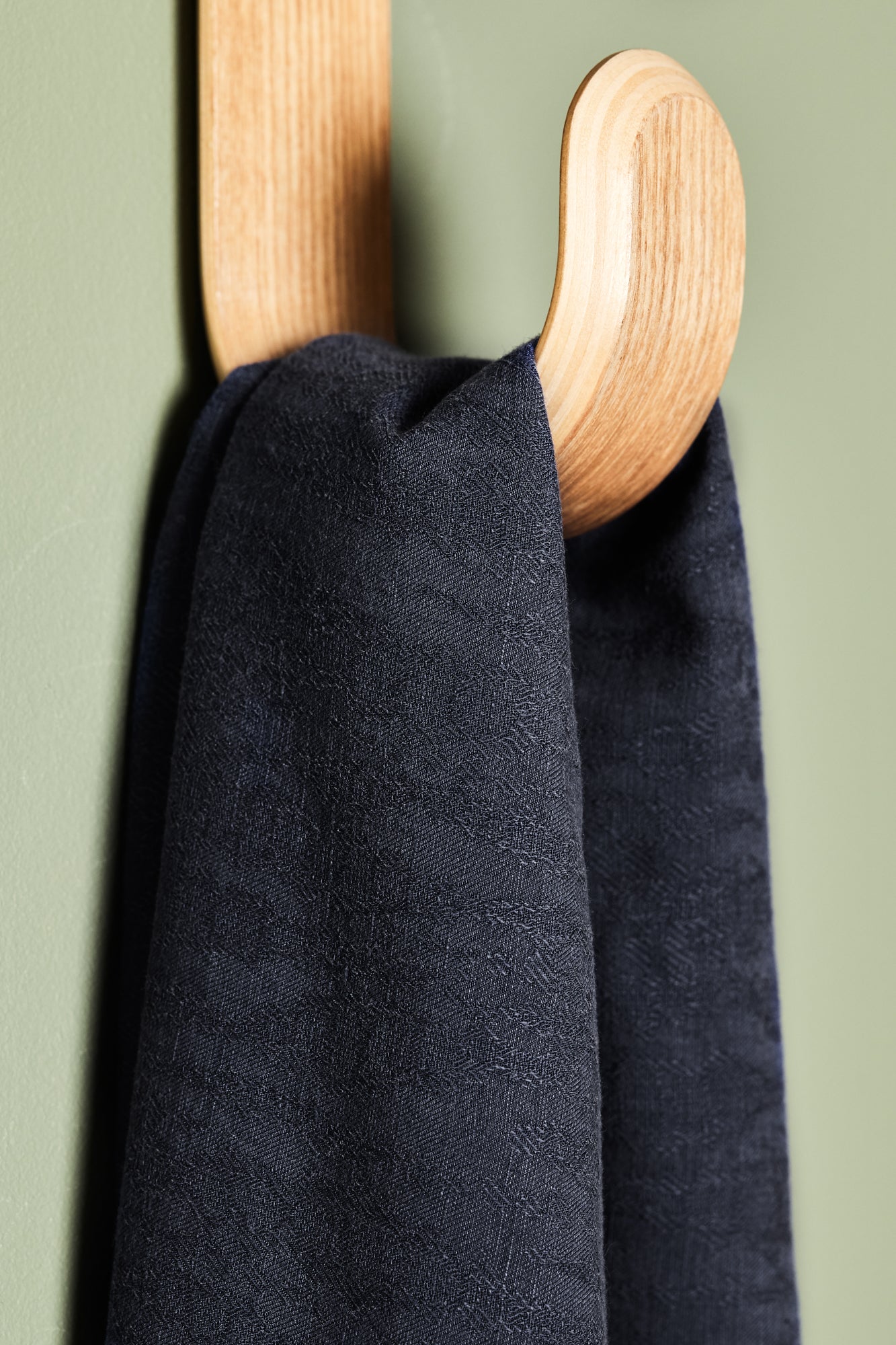 Close up of linen and tencel blend sewing fabric hanging on hook in navy