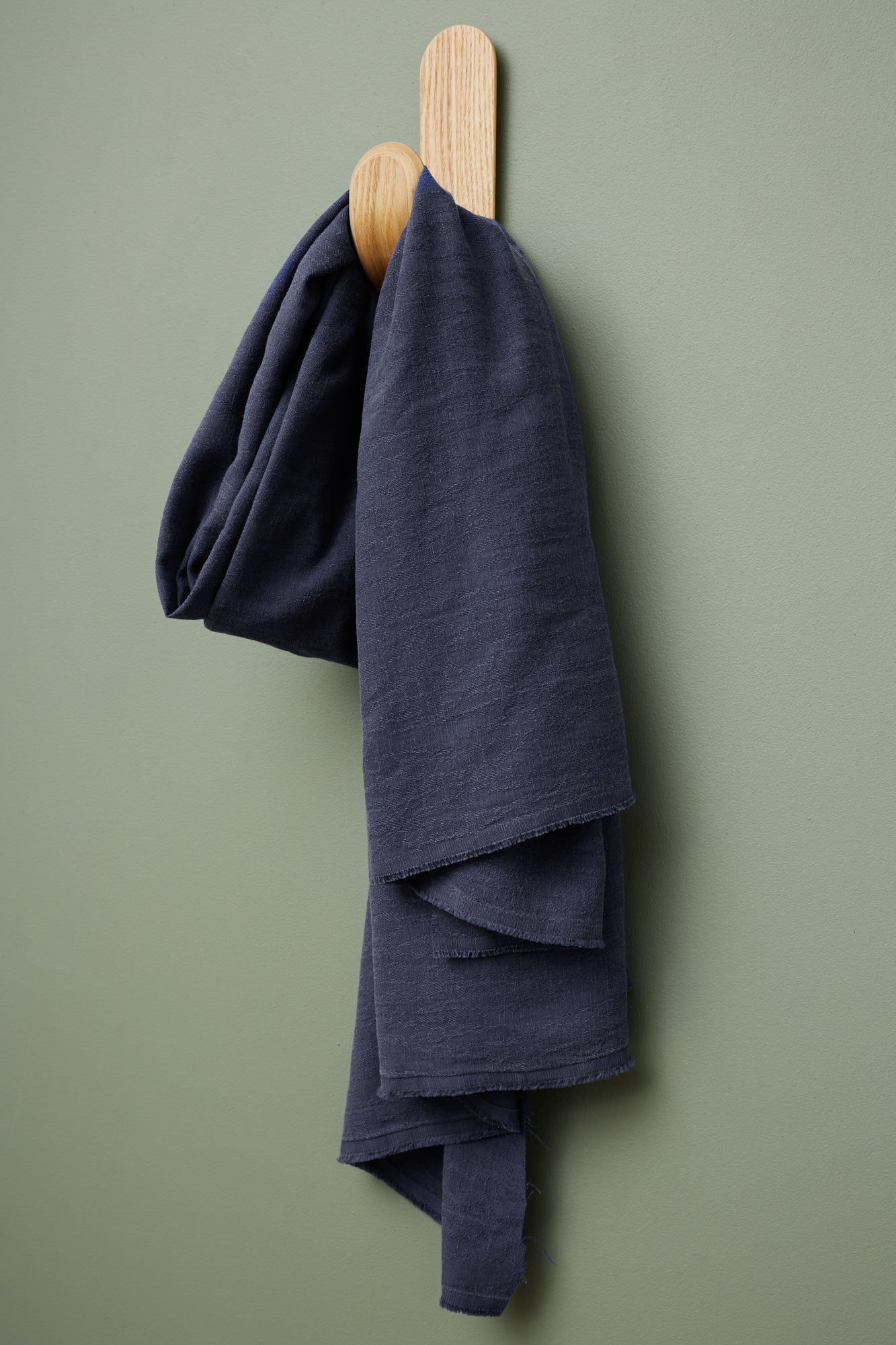 Linen and tencel blend sewing fabric in navy hanging on hook