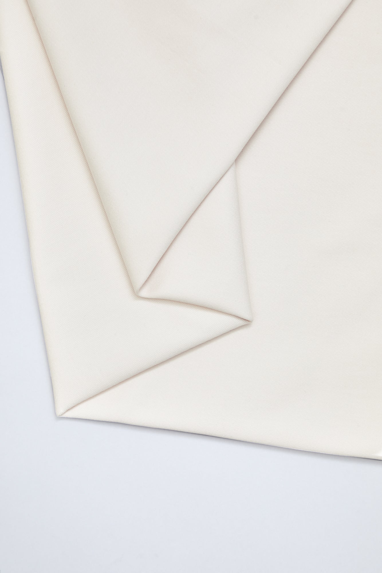 Flat lay of organic cotton twill fabric in creamy white colour