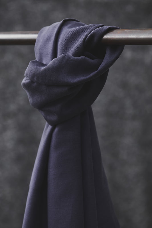 Smooth drape twill tencel sewing fabric in blueberry colour knotted over clothes rail