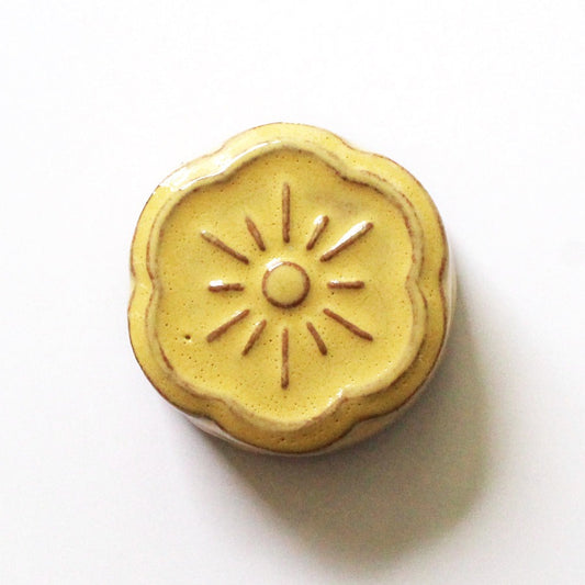 Cohana flower shaped ceramic magnetic needle rest in yellow on white background