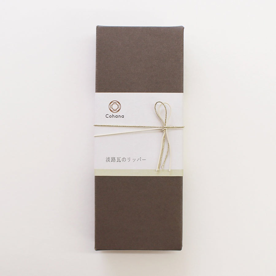Dark grey cardboard box with cohana brand and string tied around it