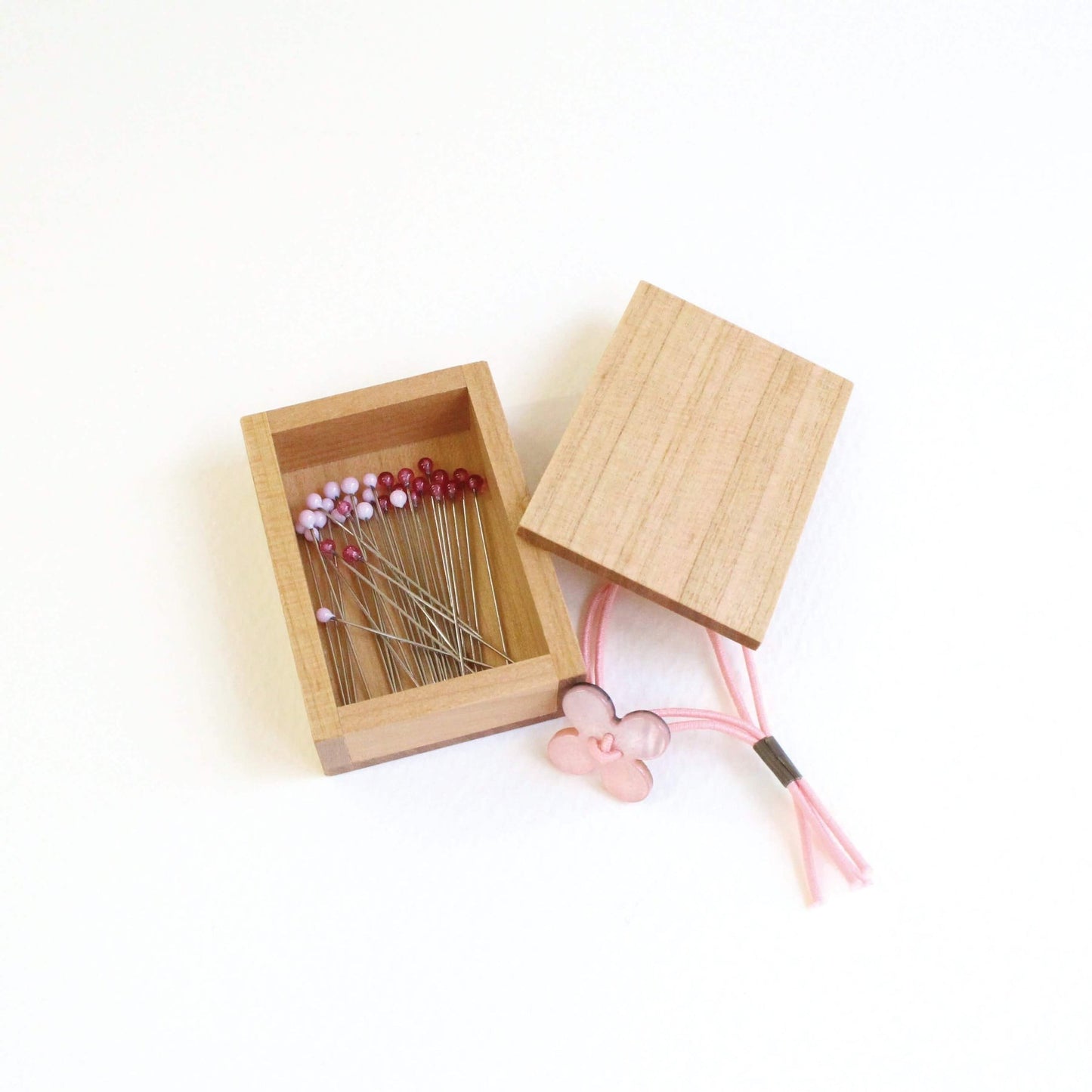 Pink cohana glass headed pins in wooden storage box