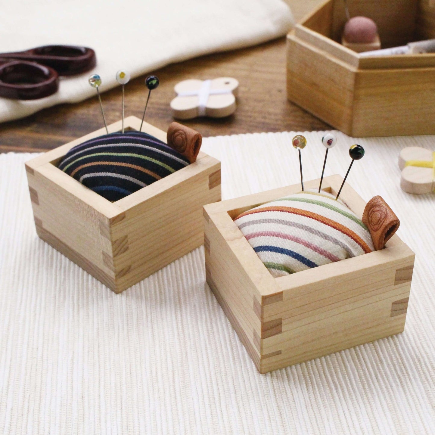 Square cohana pin cushions in black and white among haberdashery scene