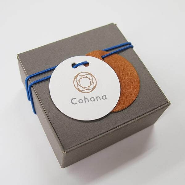 Dark grey cohana packaging box with blue elastic around it