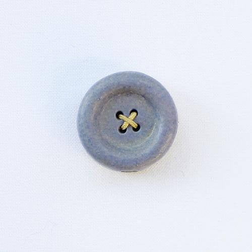 Blue button shaped needle magnet on white background