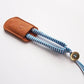 Sewing snips with blue thread wrapped handles sitting in leather case