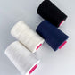 4 cones of cellulose, tencel sewing thread lying on table in natural, white, navy and black