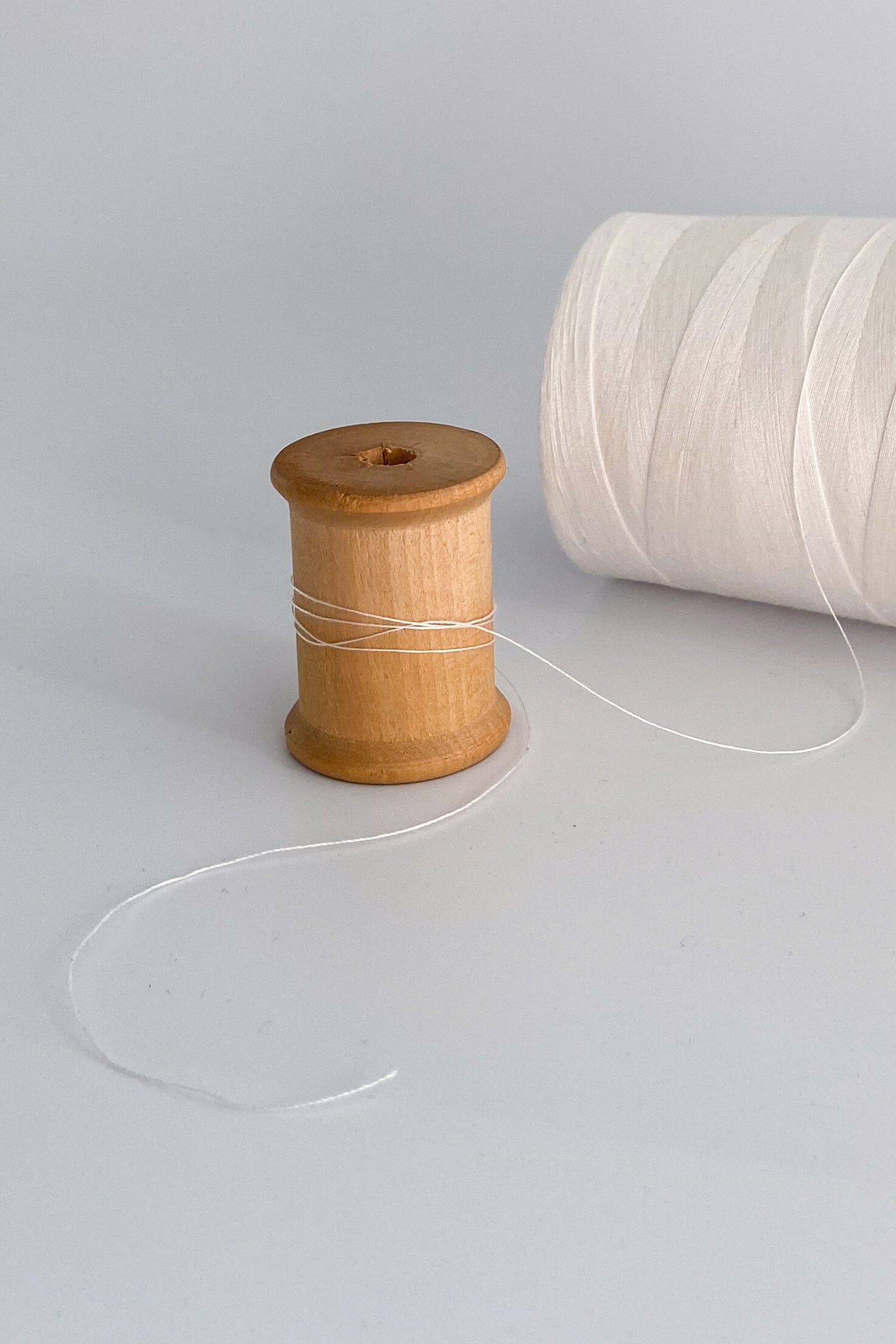 Close up of tencel sewing thread in natural wound around wooden cotton reel 