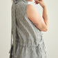 Woman wearing a sleeveless striped dress against a plain background