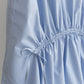 Close-up of a light blue Paloma top with a gathered tie waist