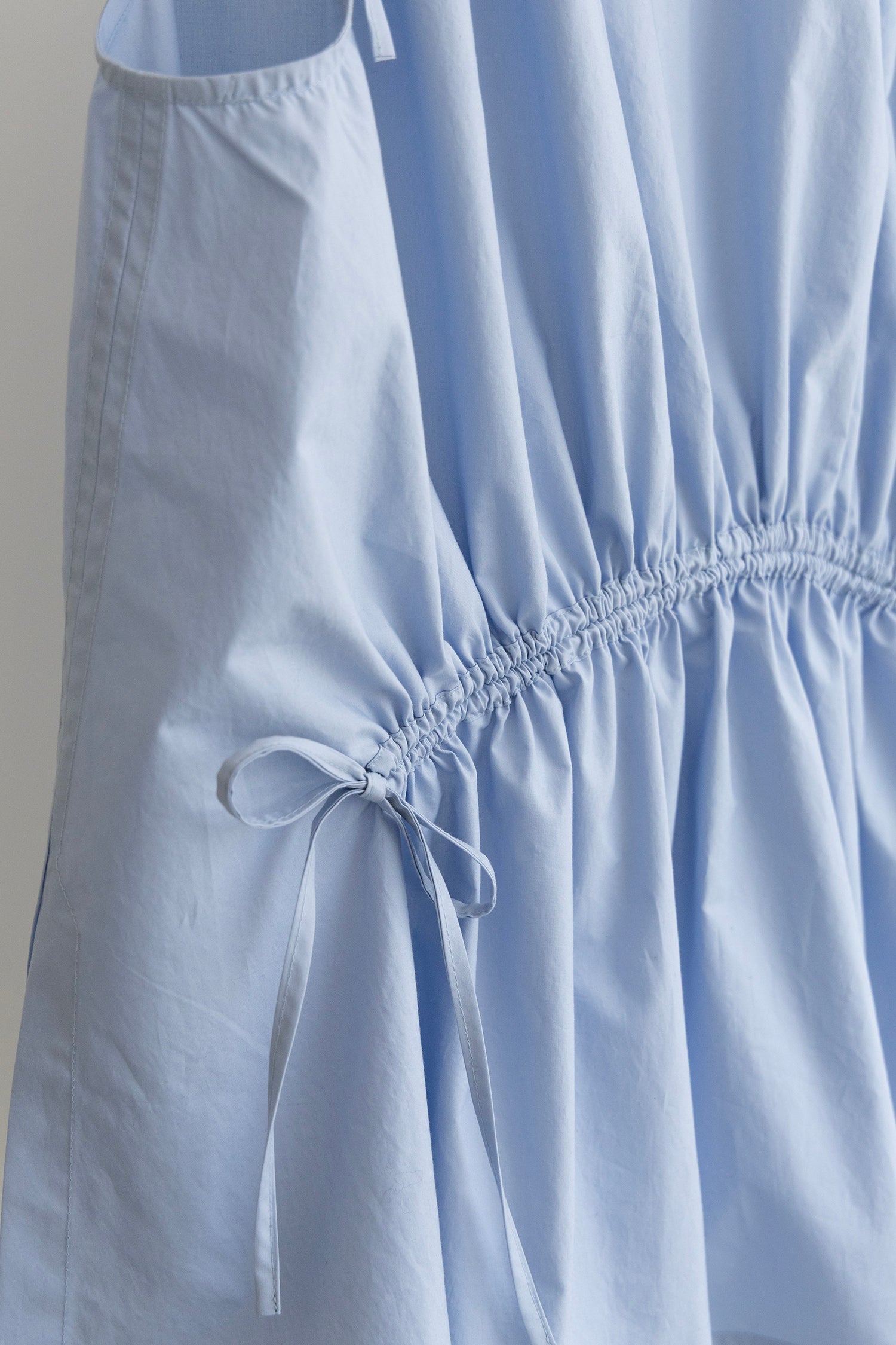 Close-up of a light blue Paloma top with a gathered tie waist
