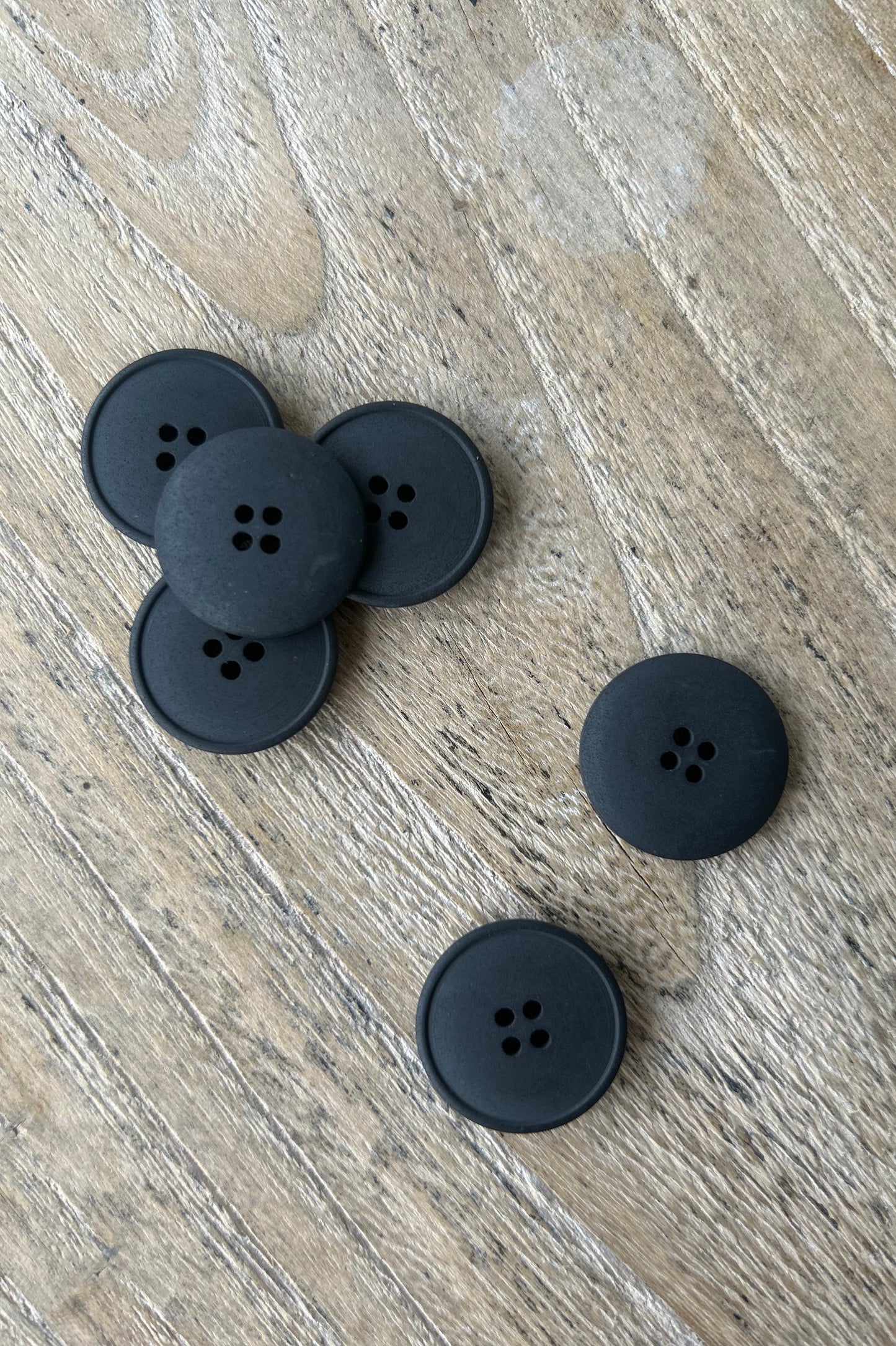 Collection of 20mm black hemp buttons on wood