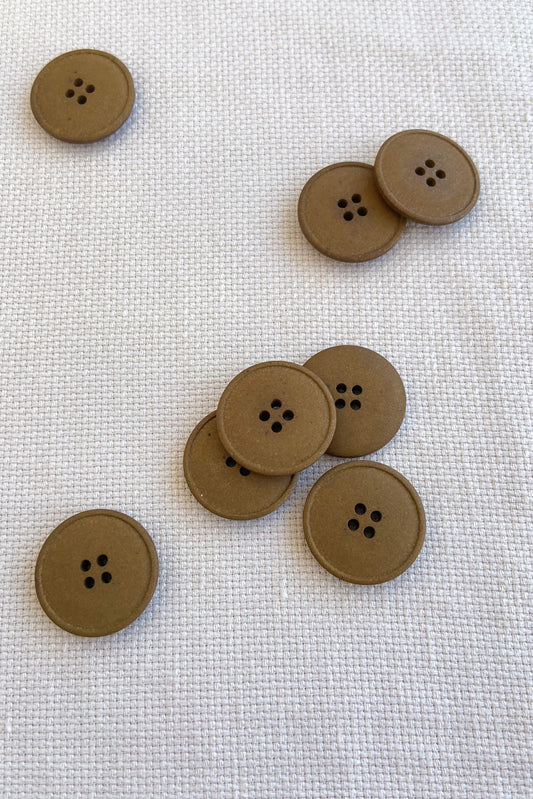 Collection of merchant and mills hemp buttons in tan colour on white cloth
