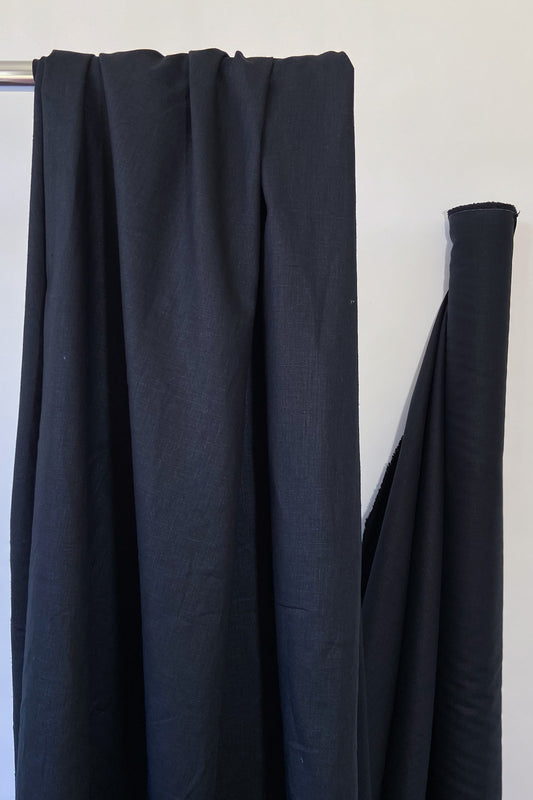 Black hemp and organic cotton woven sewing fabric hanging over rail