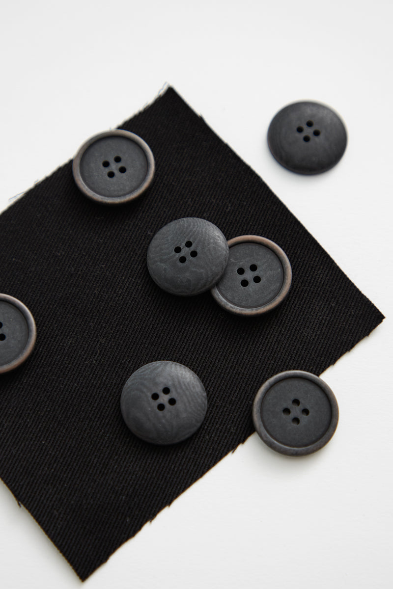Close up of pile of black corozo sewing buttons  