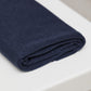 Navy organic cotton and tencel jersey sewing fabric folded on top of white table