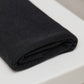 Black organic cotton and tencel knit sewing fabric folded on top of white table