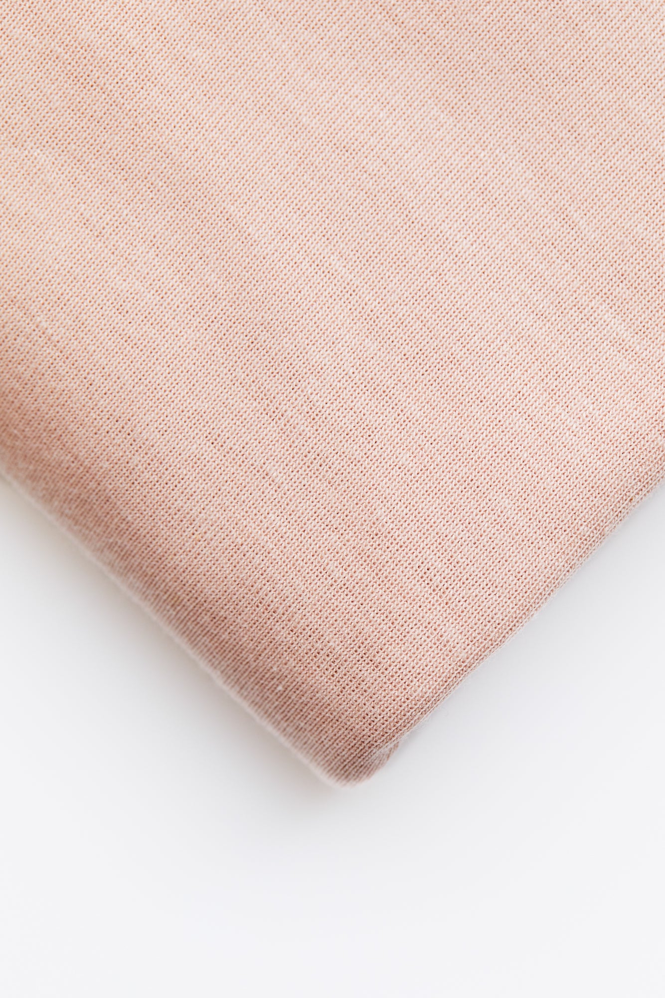 Close up of powder pink organic cotton and tencel knit jersey sewing fabric 