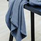 Mara linen blend tencel sewing fabric in dusty blue, draped over stool