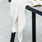 Mara linen blend tencel sewing fabric in colour shell, draped over black stool