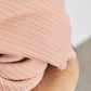 Close up of chunky organic cotton ribbed knit sewing fabric in colour rose