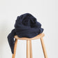 Chunky organic cotton ribbed knit sewing fabric in colour navy, piled on top of wooden stool