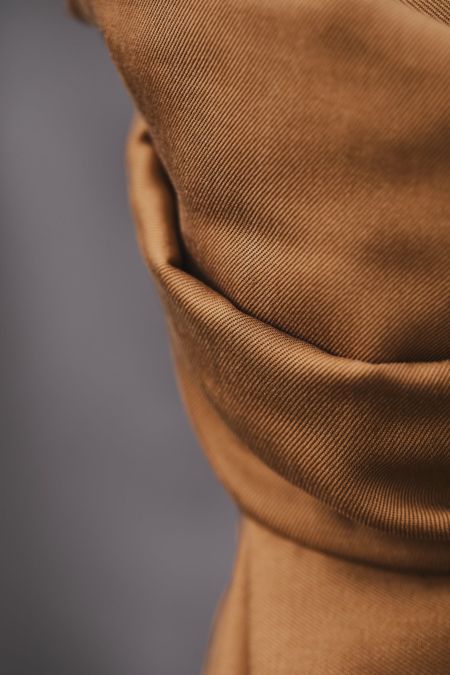 Close up of smooth drape twill tencel sewing fabric in colour mustard