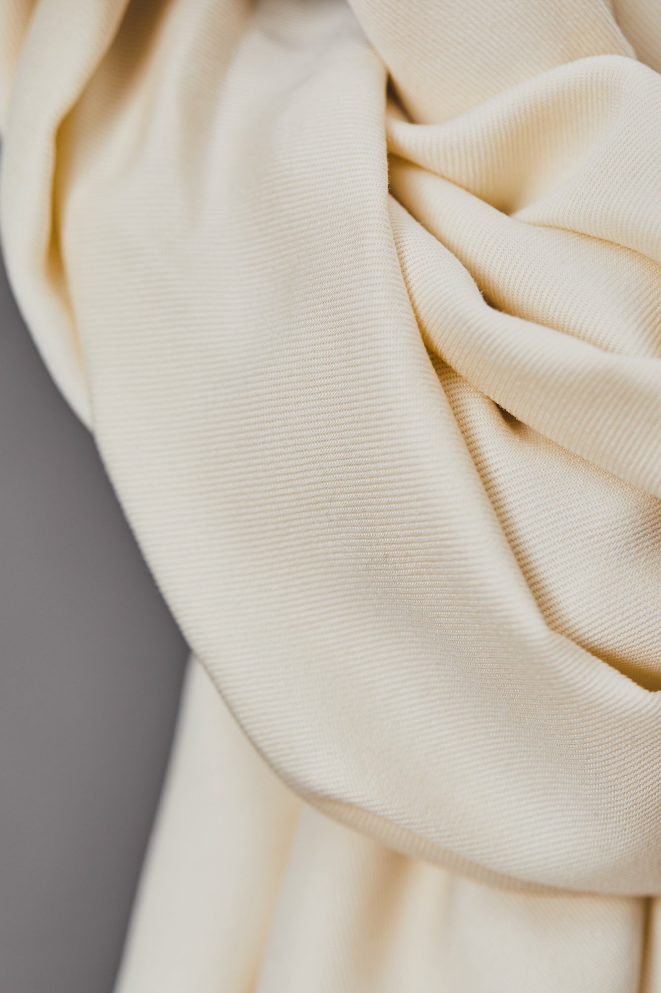 Close up of smooth drape twill tencel fabric in shell (cream)