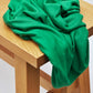 Ecovero knit sewing fabric in frog green draped over wooden bench