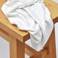 White Ecovero knit sewing fabric draped over wooden bench