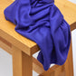 Lapis (bright blue) Ecovero knit sewing fabric piled on wooden bench