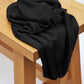 Black Ecovero knit sewing fabric draped over wooden bench
